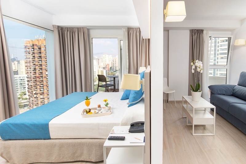 Superior Familiar - una habitación de hotel con una cama y un sofá