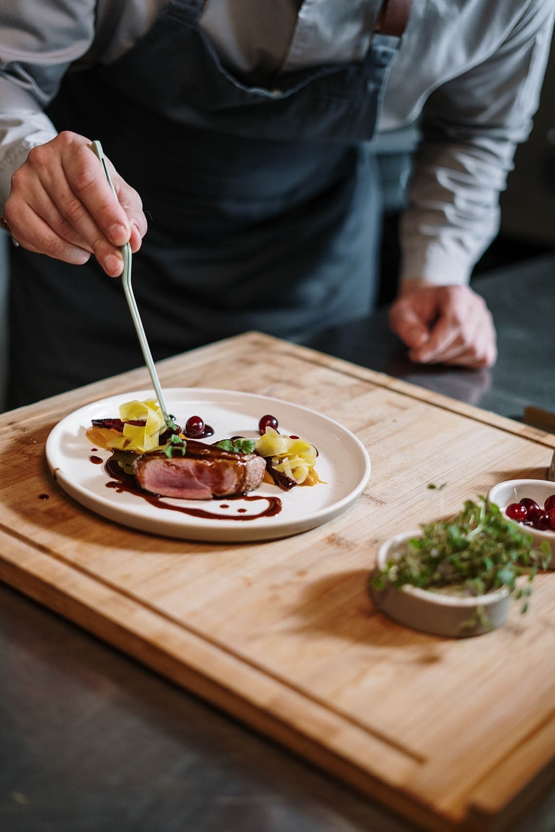un chef decora un plato de comida con un pincel