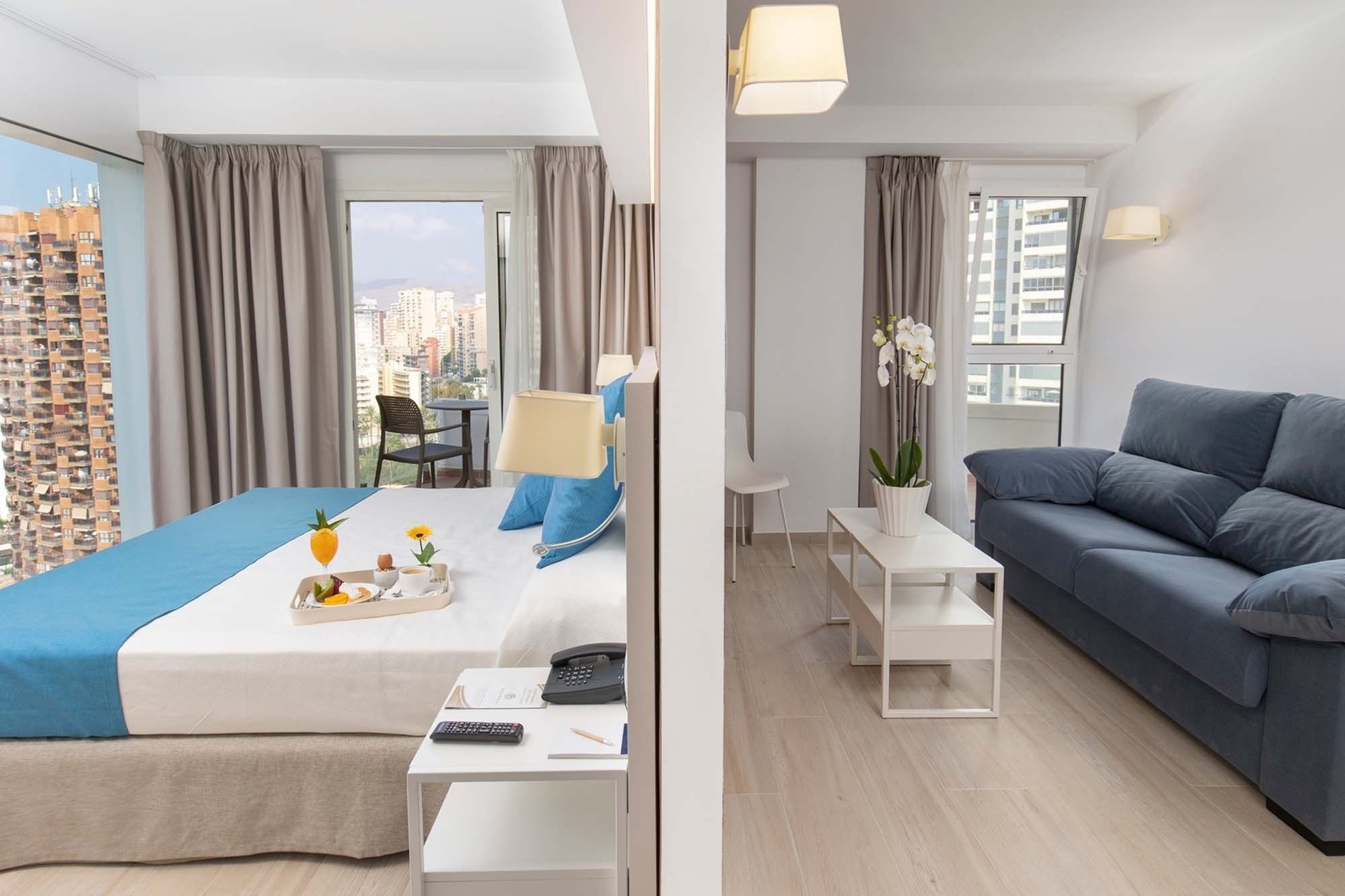 una habitación con una cama azul y un sofá azul