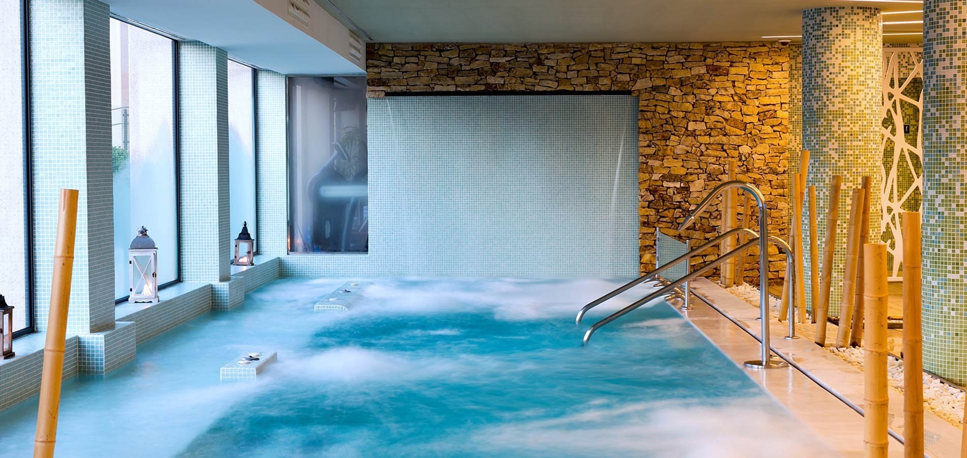 a swimming pool with a stone wall behind it