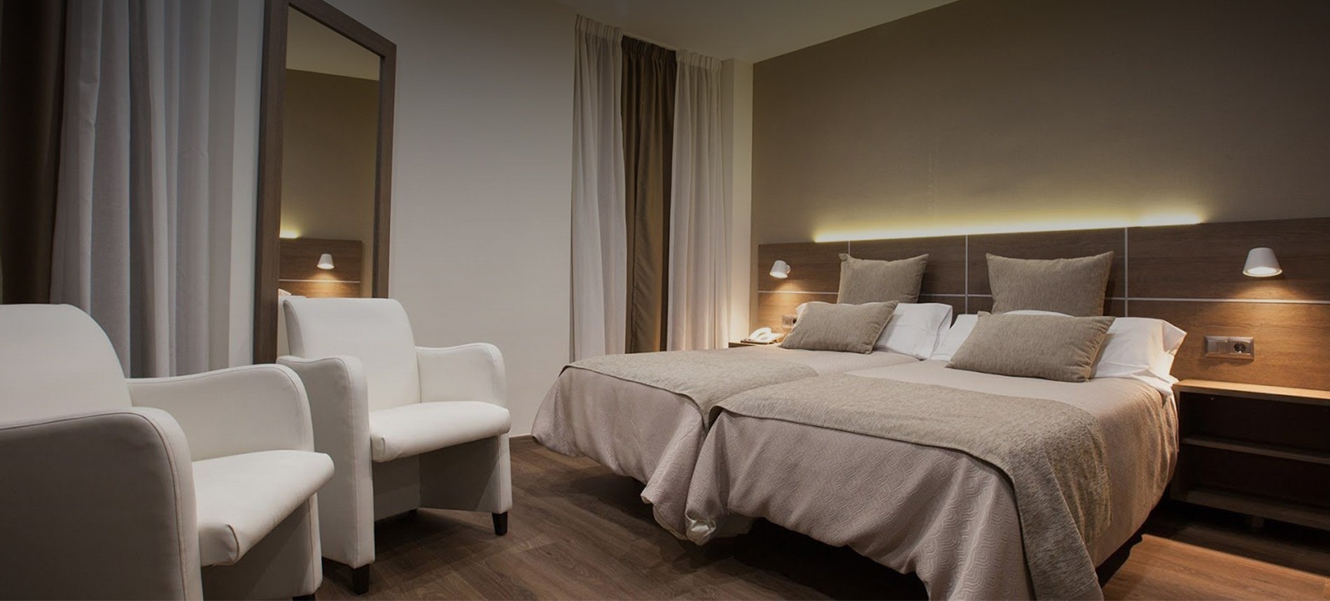 a hotel room with two beds and two chairs