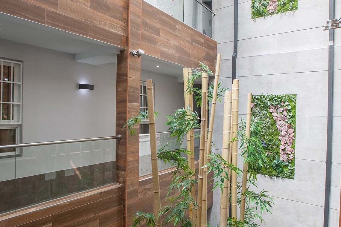 a building with a balcony and a wall with flowers on it