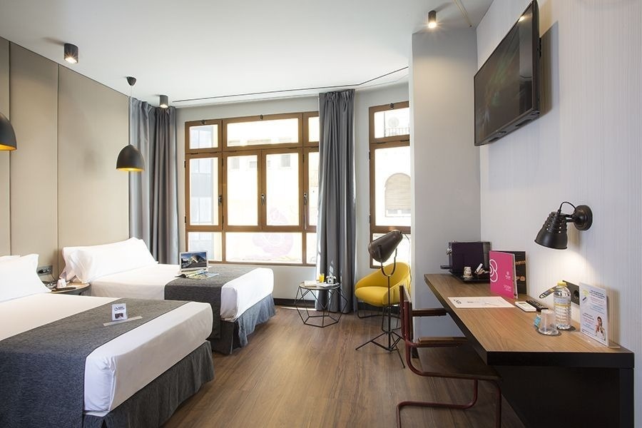 una habitación de hotel con dos camas y una televisión