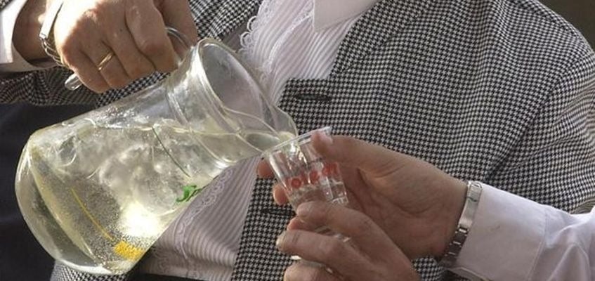 une personne verse de l' eau d' un pichet dans un verre