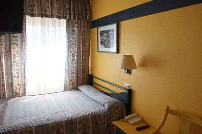 una habitación amarilla con una cama y una lámpara