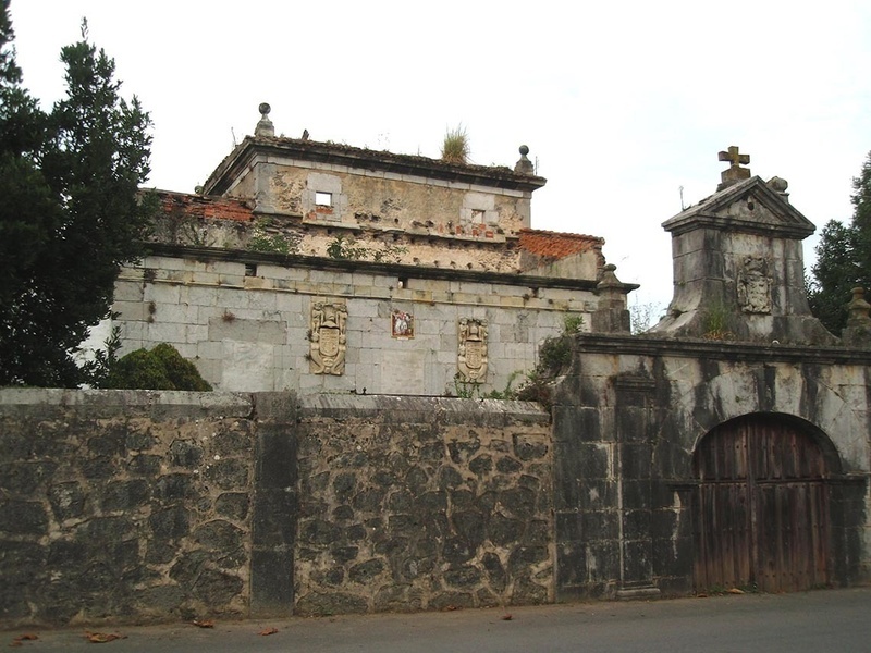 un edificio antiguo con una puerta de madera y una cruz