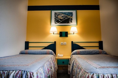 a hotel room with two beds and a picture on the wall - 