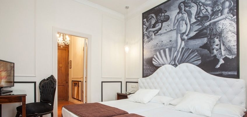 una habitación con una cama y una pintura en la pared