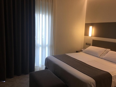 una habitación de hotel con una cama y una ventana