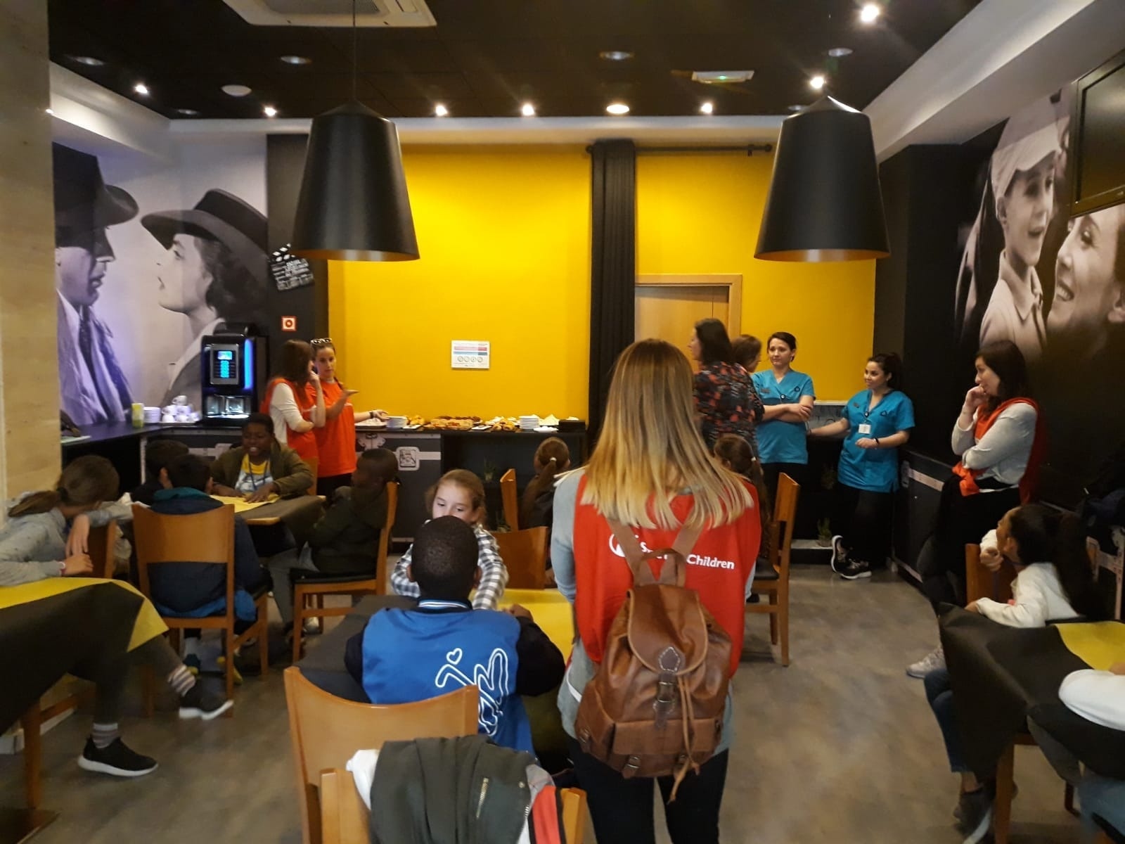 una mujer con una mochila roja con la palabra niños en la espalda