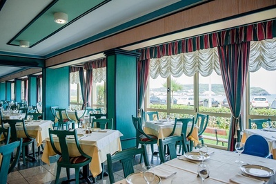 un restaurante con sillas verdes y mesas blancas - 