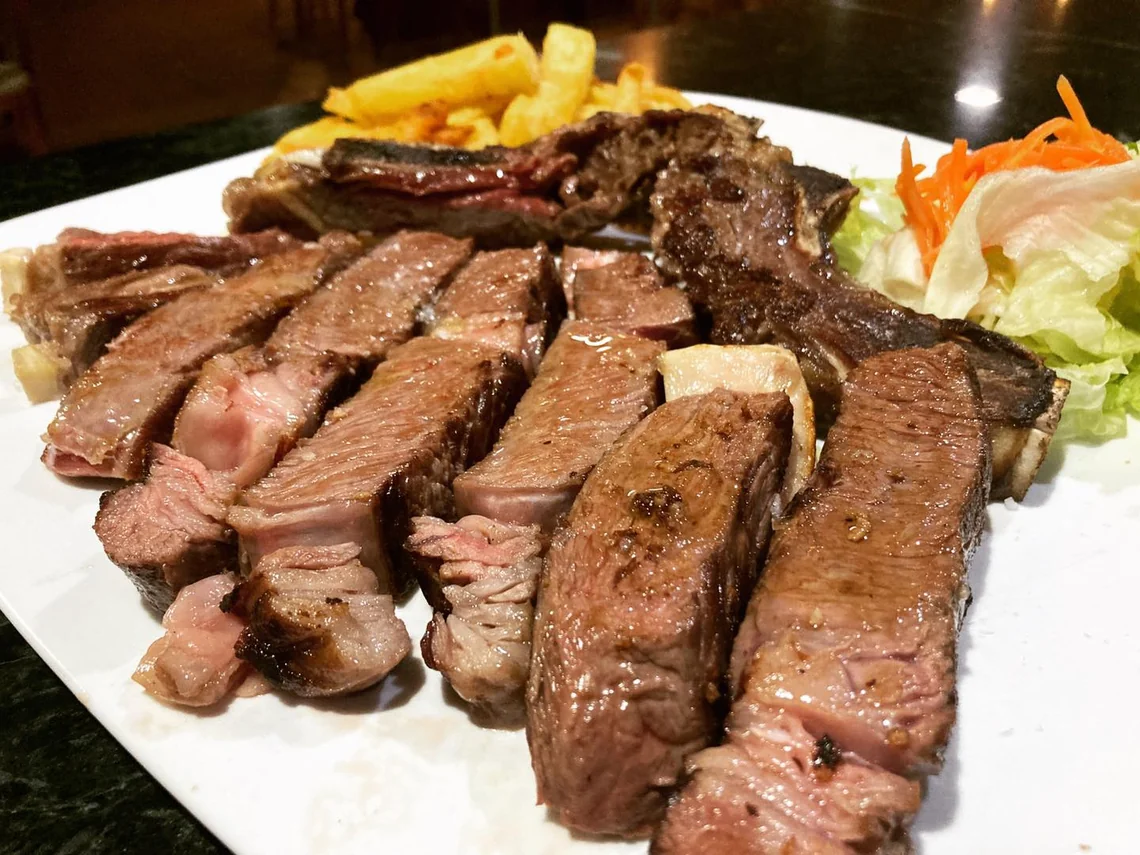 Hotel Acosta Ciudad de la Música de jugoso corte de carne de res servido con papas fritas y ensalada fresca.