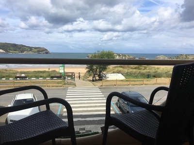 a view of the ocean from a balcony with two chairs