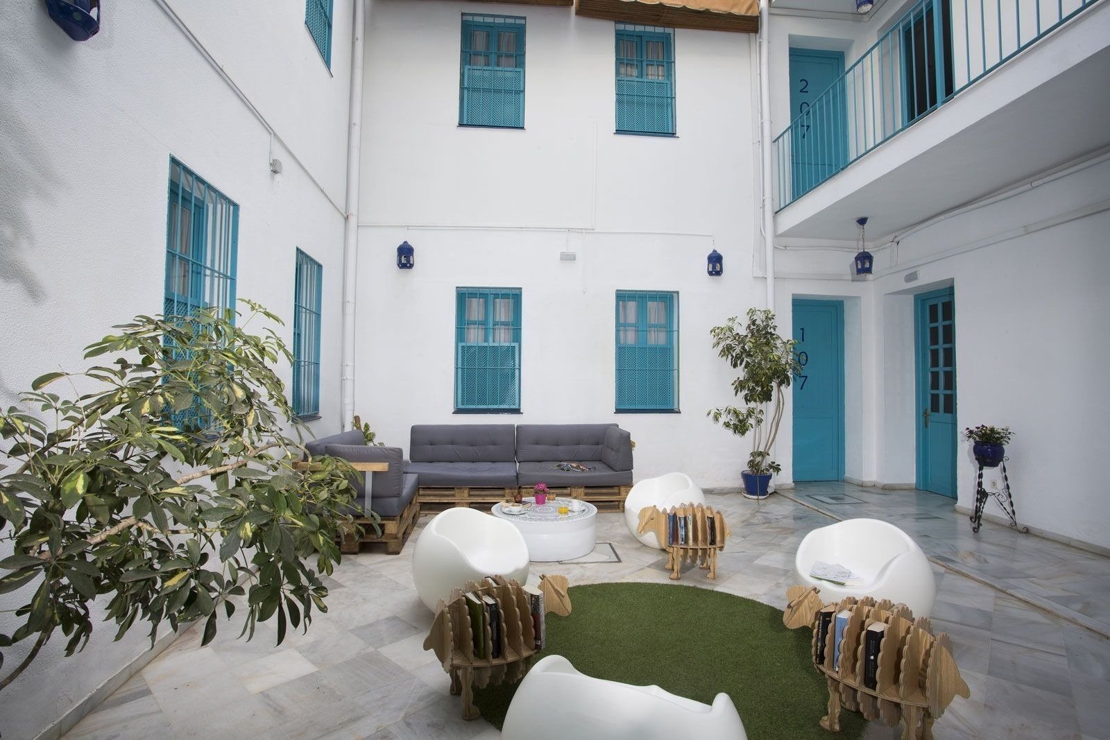 un patio con muebles blancos y azules y la puerta 107