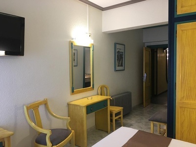 a hotel room with a table and chairs and a television