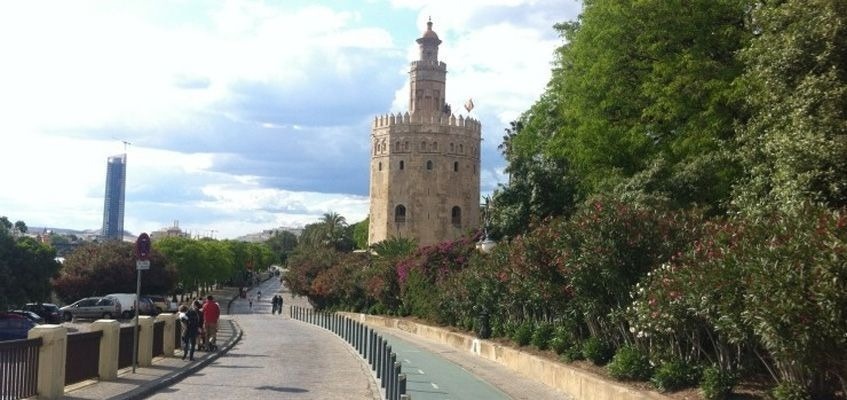 un gruppo di persone sta camminando lungo una strada accanto a una torre