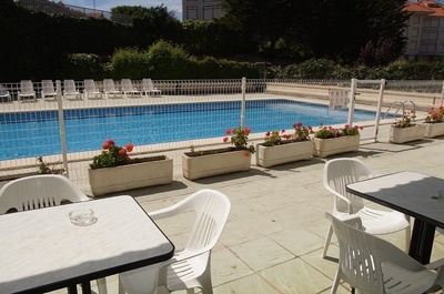 una mesa y sillas frente a una piscina - 