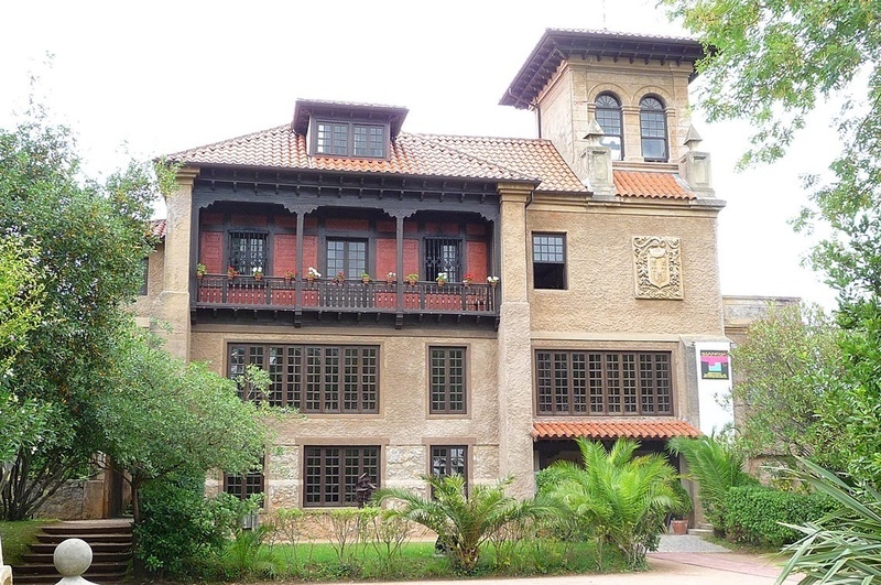 un gran edificio de hormigón con un escudo de armas en la torre