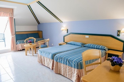 a hotel room with two beds and two chairs