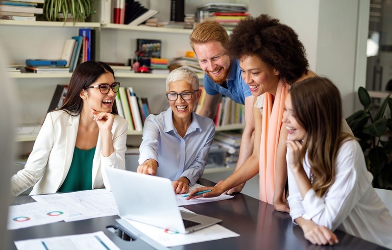 un groupe de personnes regarde un ordinateur portable