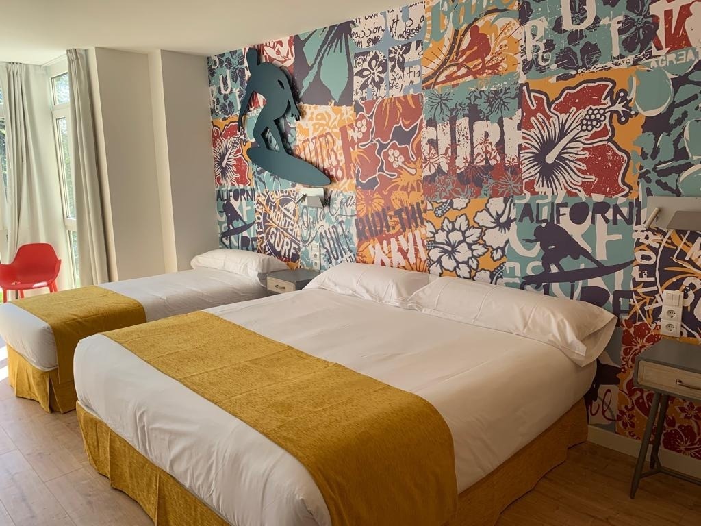 una habitación con dos camas y un mural que dice california surf