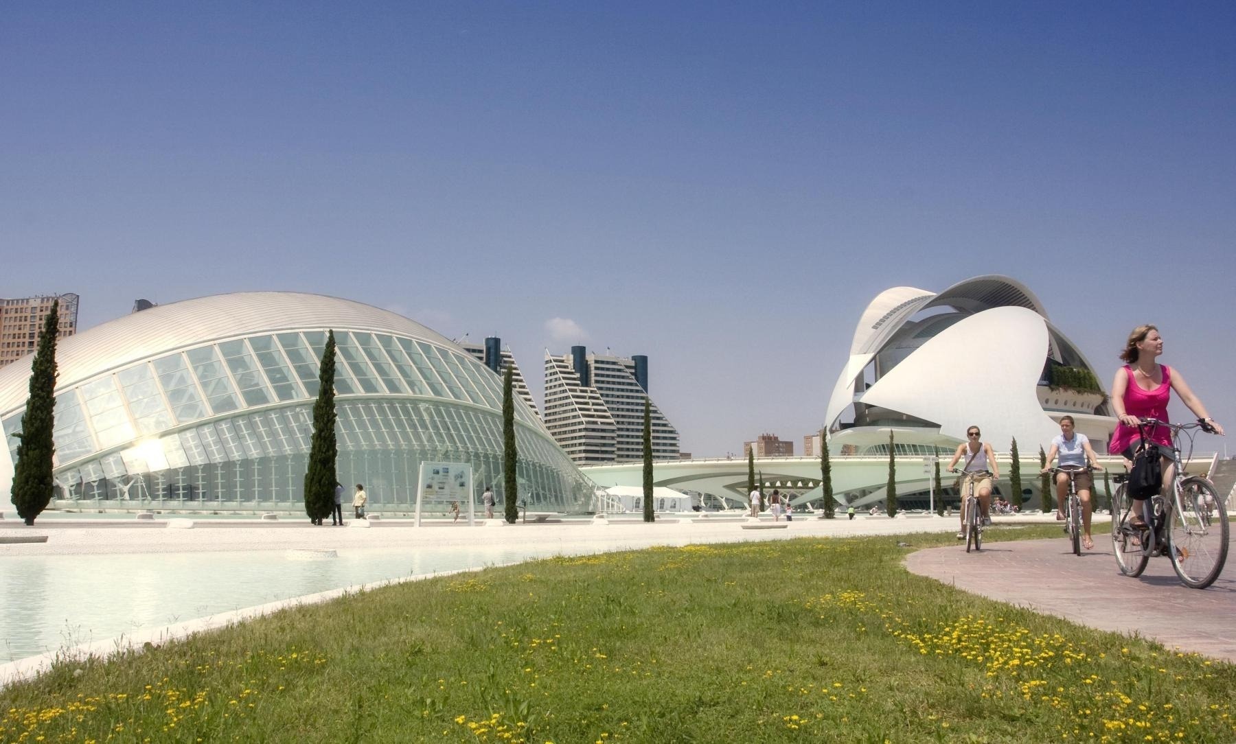 dos mujeres andan en bicicleta frente a un edificio moderno