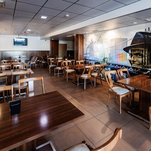 Elegant hotel dining room with Sinatra mural, modern tables, and chairs. Hotel Acosta Ciudad de la Música