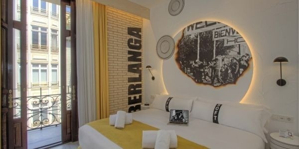 una habitación de hotel con una cama y una computadora portátil encima de ella .