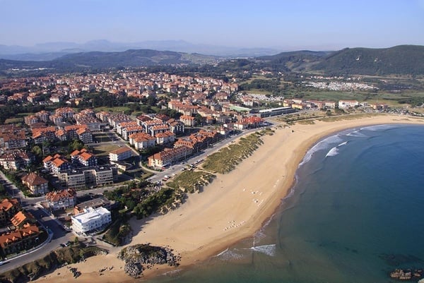 an aerial view of a beach with a city in the background