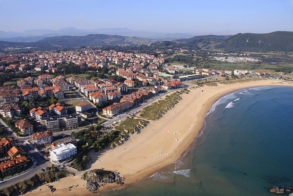 una vista aérea de una playa con una ciudad al fondo