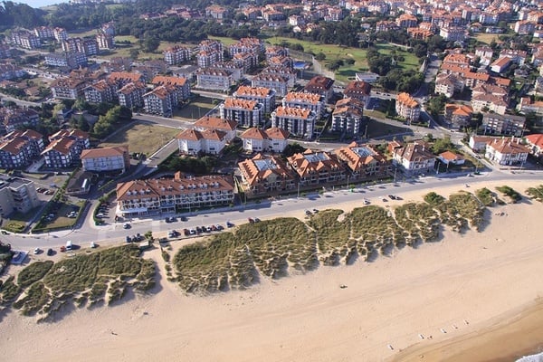an aerial view of a city with a beach in the foreground