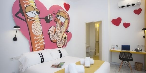 una habitación con una cama , escritorio y corazón en la pared .