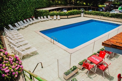 a swimming pool surrounded by chairs and a table that says mahou on it - 