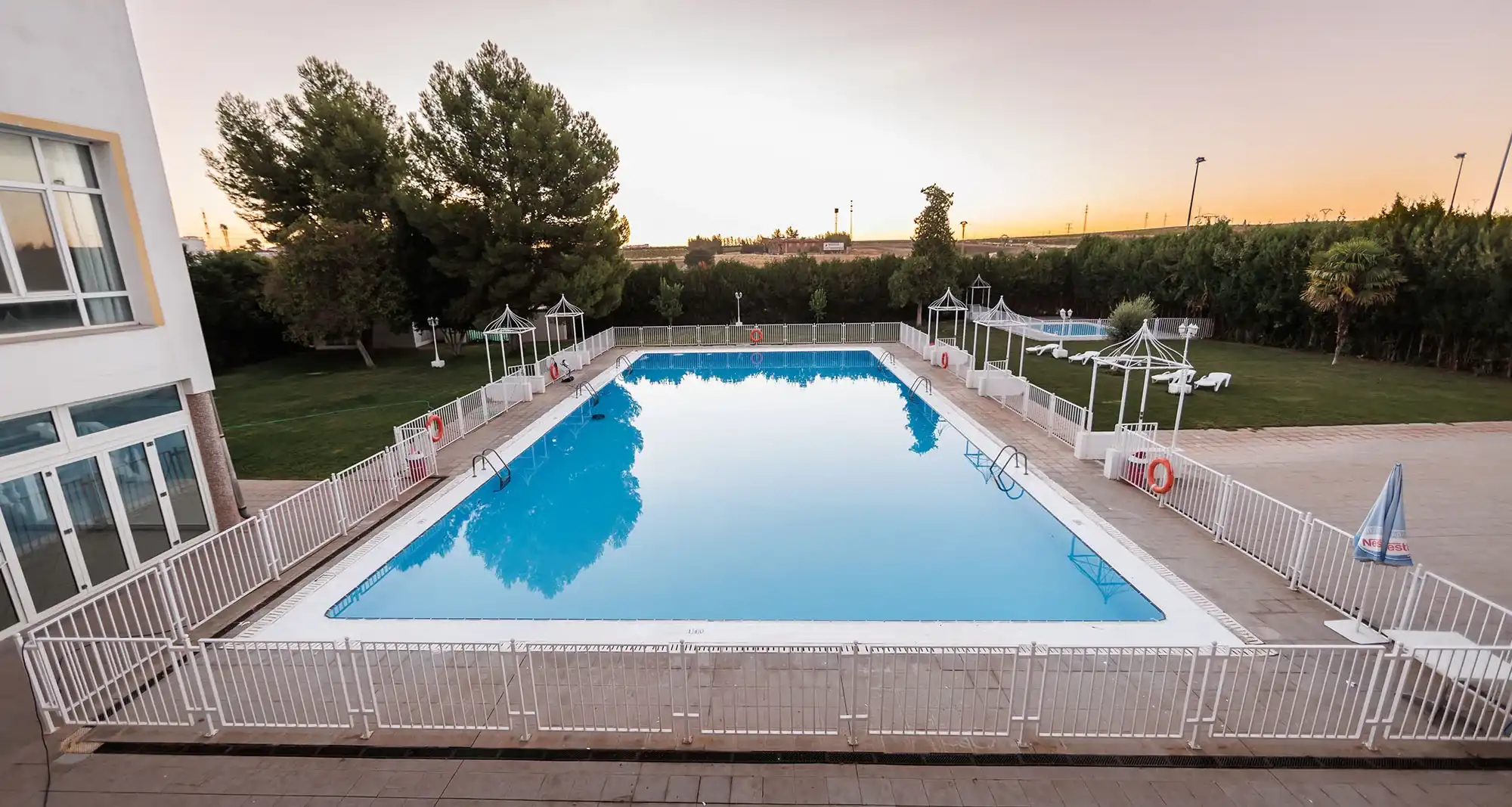 Amplia piscina y césped en un hotel con Hotel Acosta Ciudad de la Música, ideal para vacaciones.