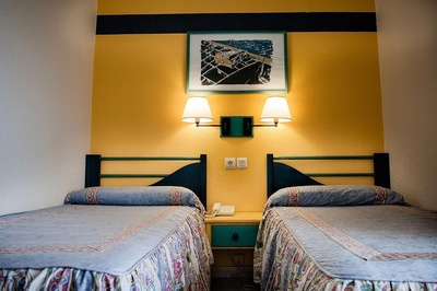 a hotel room with two beds and a picture on the wall