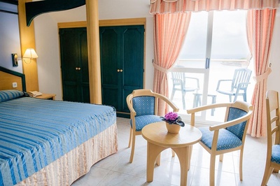 a hotel room with a canopy bed and chairs