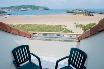 a view of a beach from a balcony with two chairs - 