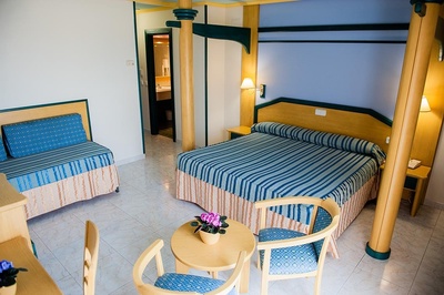 una habitación de hotel con una cama y dos sillas - 