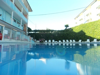 una piscina llena de sillas y un edificio en el fondo - 