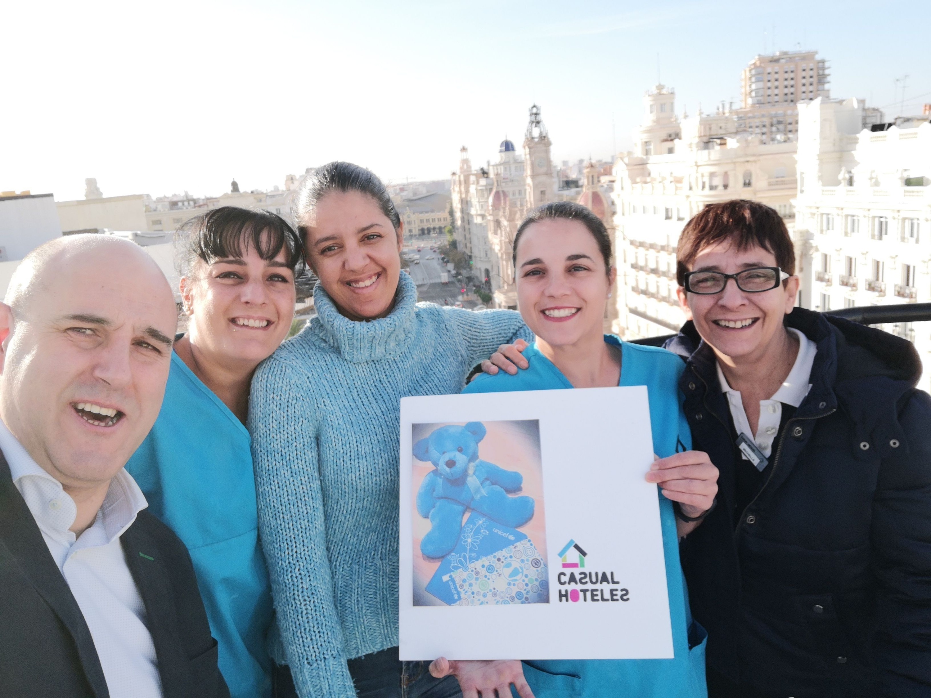 un grupo de personas sostiene un cartel que dice casual hotel 2