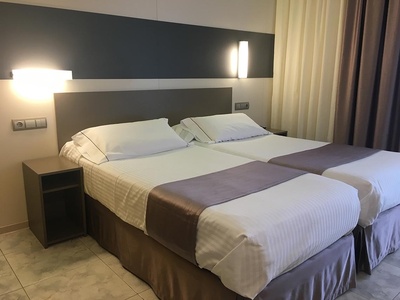 a hotel room with two beds and a nightstand