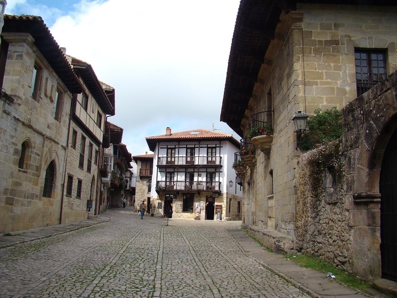 a cobblestone street between two buildings with balconies