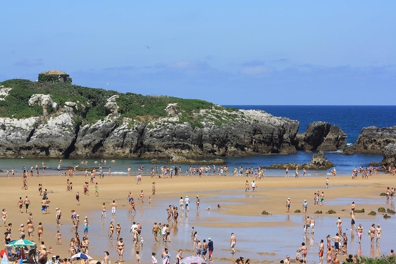 una playa llena de gente en un día soleado