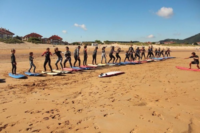 a group of people standing on surfboards on a beach - 