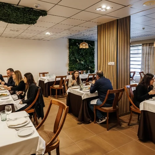 Diners enjoying a meal at a hotel restaurant, perfect for your Hotel Acosta Ciudad de la Música stay.