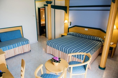 a hotel room with a striped bed and chairs