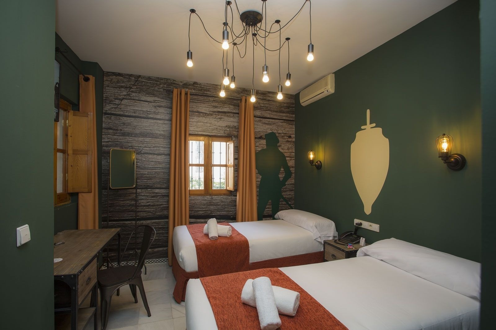 una habitación con dos camas y una pared verde