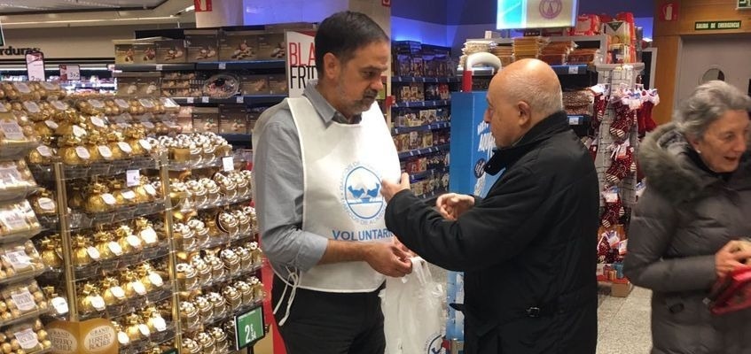 un hombre con un chaleco de voluntarios en un supermercado
