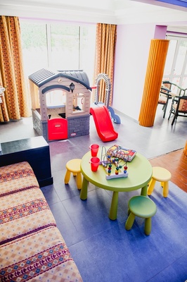a children 's play area with a little tikes house and a slide - 