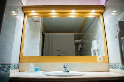 un lavabo en un baño con un espejo y un secador de pelo